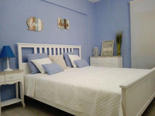 アルマカオ・デ・ペラにあるSummer Homeのベッドルーム1室(青い壁の大きな白いベッド1台付)
