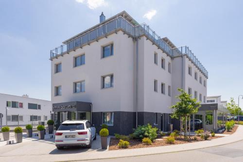 a white car parked in front of a building at hotel bomonti Nürnberg West in Oberasbach