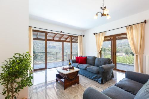 a living room with a couch and a table at Villa Asigonia with Heated Pool & Whirlpool in Asigonía