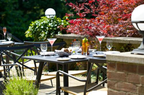 a table with glasses and plates on it in a garden at The Manor at Sway – Hotel, Restaurant and Gardens in Sway