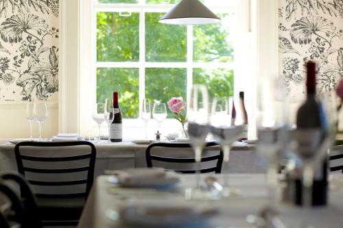 a table with wine bottles and a flower on it at The Manor at Sway – Hotel, Restaurant and Gardens in Sway