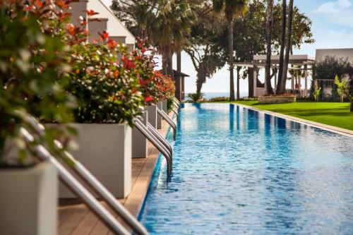 a swimming pool in a resort with flowers and plants at Acanthus Cennet Barut Collection - Ultra All Inclusive in Side
