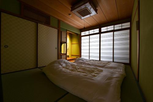 a large bed in a room with a window at Shibashi Umeyacho in Kyoto