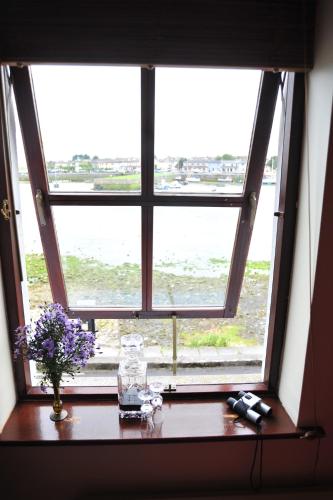a window with a vase of flowers on a table at The Herons Rest Townhouse B&B in Galway