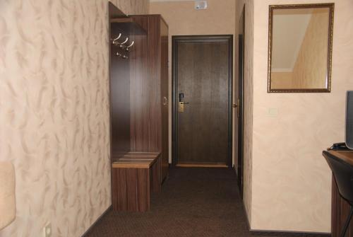 a hallway with a door and a mirror on the wall at Globus Hotel in Ternopilʼ