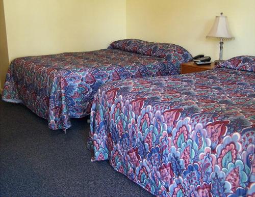 LanesboroughにあるWeathervane Motel Lanesboroのベッド2台、電話(テーブル上)が備わる客室です。