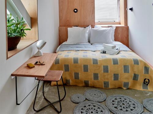 a small bedroom with a bed and a table at Q-Factory Hotel in Amsterdam