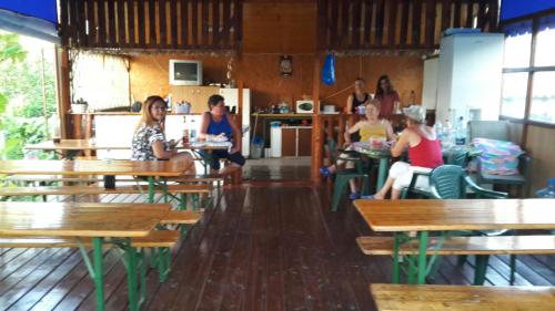 un grupo de personas sentadas en mesas en un restaurante en Casa Mihai, en Costinesti