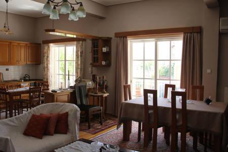 kuchnia i salon ze stołem i krzesłami w obiekcie Family house w Kalamácie
