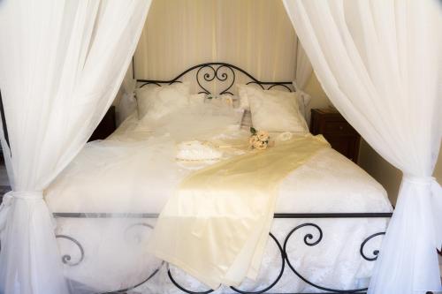 a white bed with two teddy bears sitting on it at Casa Isabella B&B in Rocca San Giovanni