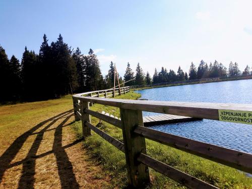 a fence next to a lake with a sign on it at Apartma David Rogla in Zreče