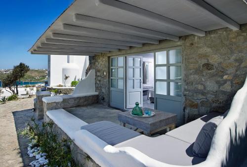 a patio with a couch and a table at Kallos of Mykonos - previous Leonis Summer Houses in Ornos