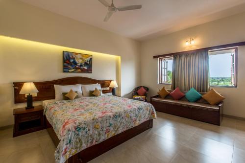 1 dormitorio con cama, ventana y sofá en Viva Hotel, en Margao