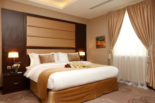 a hotel room with a large bed with flowers on it at Swiss Flora Inn Hotel Riyadh in Riyadh