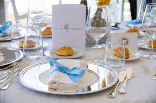 a table with plates of food and wine glasses at Hotel Tonnara Trabia in Trabia