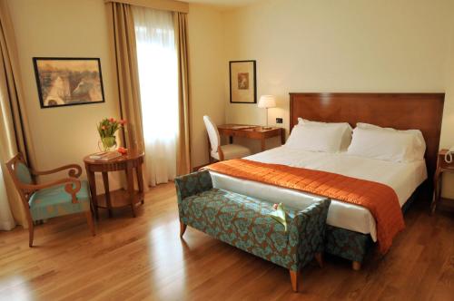 um quarto de hotel com uma cama e uma cadeira em Dependance Lipa em Basovizza