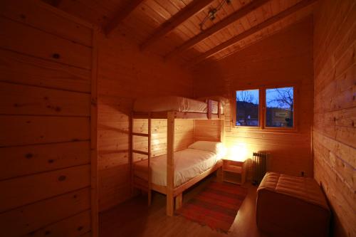 um quarto com um beliche num chalé de madeira em La Cabaña Rural em Paúl
