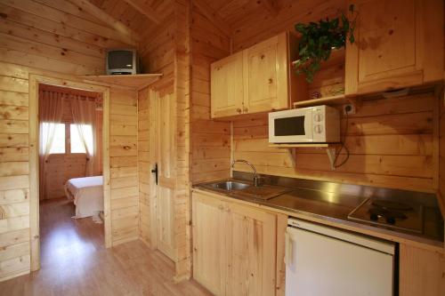 una cocina en una cabaña de madera con microondas en La Cabaña Rural, en Paúl