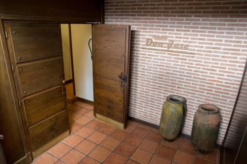 a room with a brick wall and a door and two vases at Hotel Aida in Torrejón de Ardoz