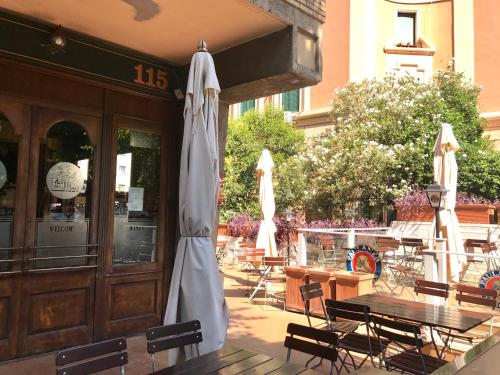 an outdoor patio with tables and chairs and an umbrella at The Queen in Rome