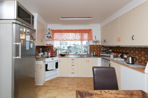 cocina con nevera de acero inoxidable y ventana en Blómasetrið Homestay, en Borgarnes