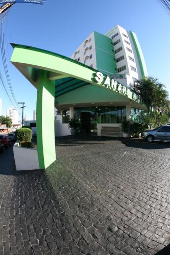 a green bench in front of a building at Sanare Hotel in Uberlândia