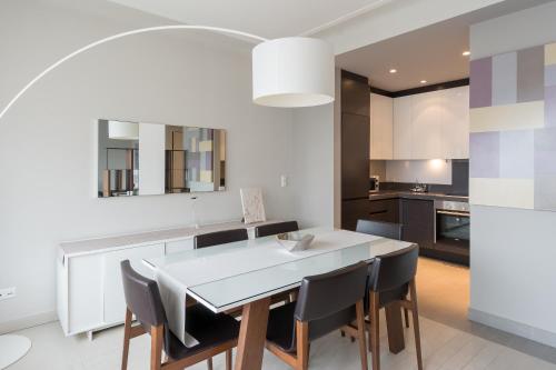 cocina y comedor con mesa blanca y sillas en Four Stars Aparthotel, en Luxemburgo