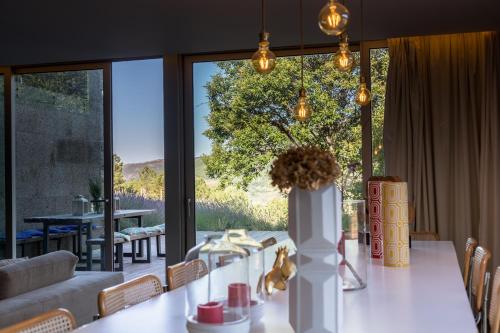 a dining room with a table and a large window at Casa de Campo De Torneiros in Unhais da Serra