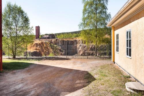 a dirt road with a fence and a building at Polhem Bed & Breakfast in Falun
