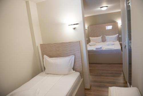 Habitación pequeña con 2 camas y espejo. en Pensiune Xe-Mar en Arad