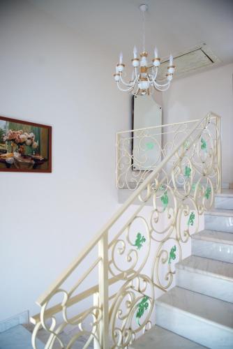 a staircase with a chandelier and a painting at Pensiune Xe-Mar in Arad