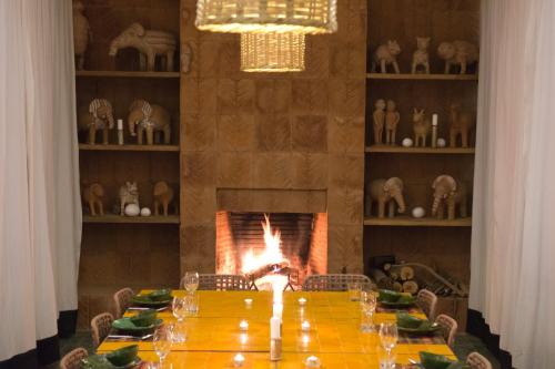 a dining room with a table and a fireplace at Dar al Hossoun in Taroudant