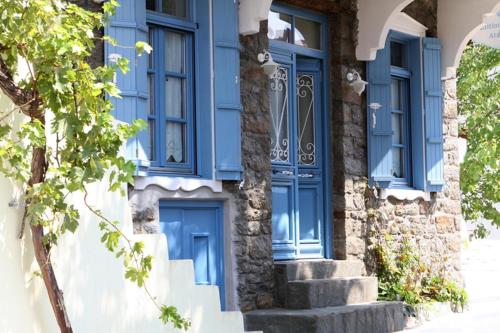 a blue door on the side of a building with stairs at Traditional Houses Atzanou in Samothráki
