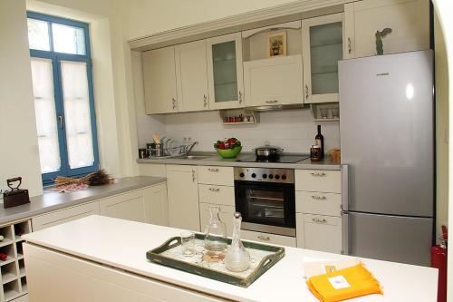 a kitchen with white cabinets and a refrigerator at Traditional Houses Atzanou in Samothráki