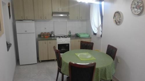 a kitchen with a table with a green table cloth at Apartman Desi in Funtana