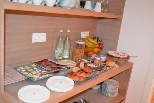 a shelf with food on it with plates and fruit at Deniké Grupo Atalaia in Santiago de Compostela