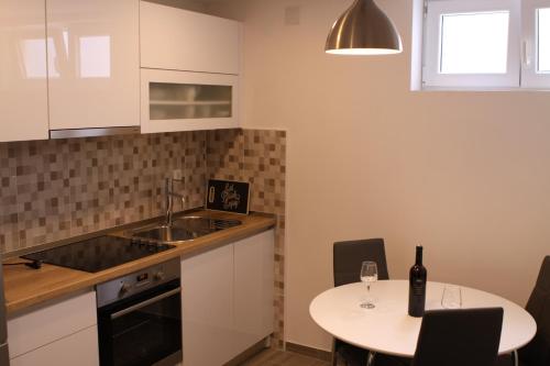 a kitchen with a table with a bottle of wine on it at Apartments Sunset in Hvar