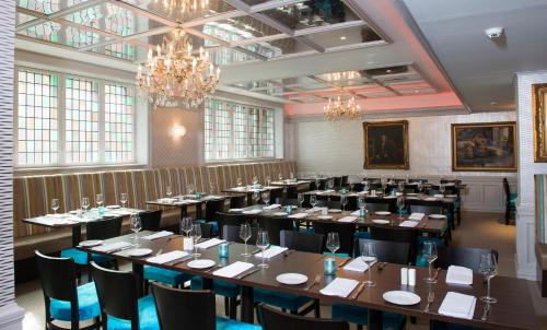 a large room with tables and chairs and a chandelier at Thon Hotel Slottsparken in Oslo