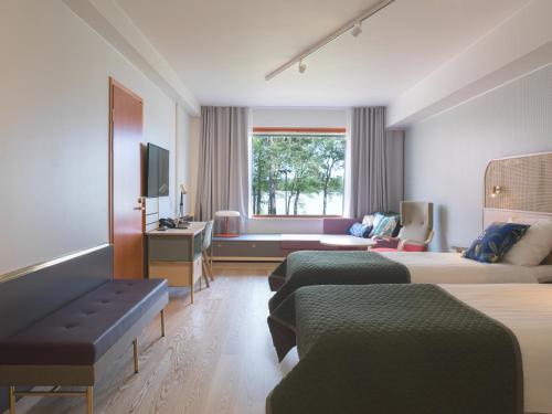 a hotel room with two beds and a couch at Hotel Hanasaari in Espoo