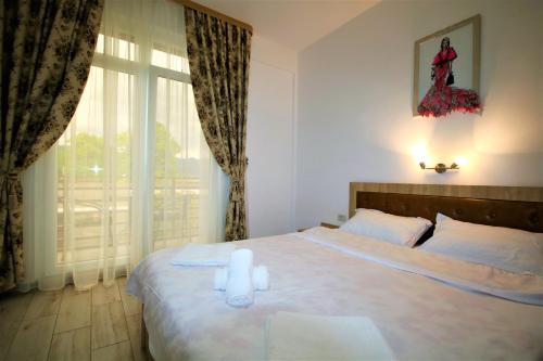 Schlafzimmer mit einem Bett mit weißer Bettwäsche und einem Fenster in der Unterkunft Aby sunrise in Orşova
