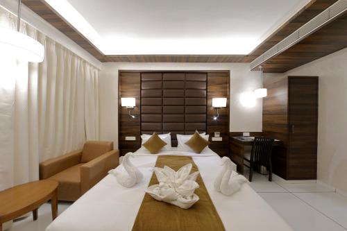 a hotel room with a bed and a desk at Hotel Silver Heights in Ahmedabad