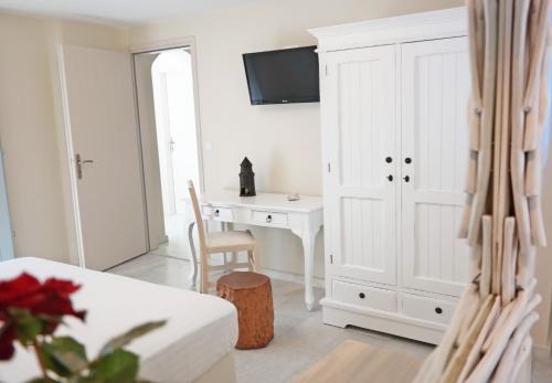 a living room with a desk and a white cabinet at Maroussa Studios in Agia Anna Naxos