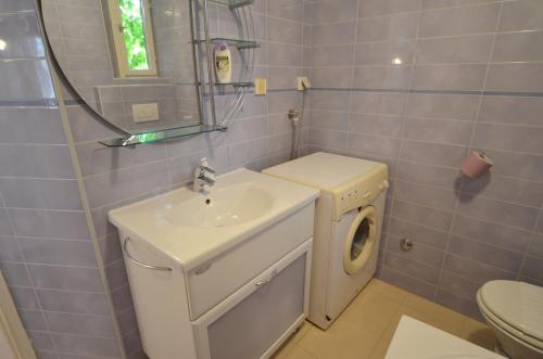 a bathroom with a sink and a washing machine at Lighthouse Montalbano in Rovinj