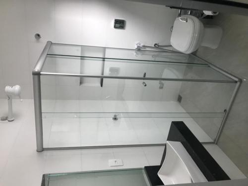a glass shelf in a room with a toilet at Hotel Cardoso in Quirinópolis