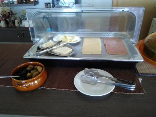 a plastic container filled with cheese and a plate of food at Hotel Theasi in Diakopto