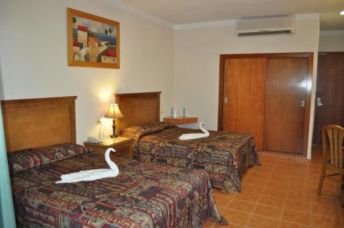 Una cama o camas en una habitación de Tecnohotel Mérida Norte