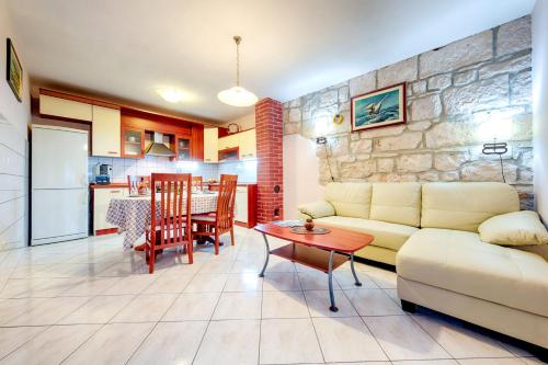 a living room with a couch and a table and a kitchen at Apartments Dalmatino in Rukavac
