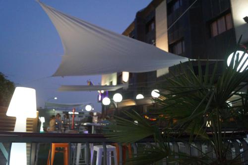 a white umbrella over a table with a plant at Hotel Aida in Torrejón de Ardoz