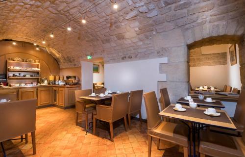 a restaurant with wooden tables and chairs and a kitchen at Hotel Lautrec Opera in Paris