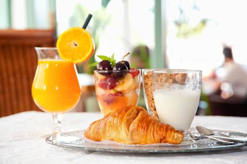 ein Tisch mit einem Teller Essen und einem Glas Orangensaft in der Unterkunft Hotel Boutique Las Arenas in Es Cana
